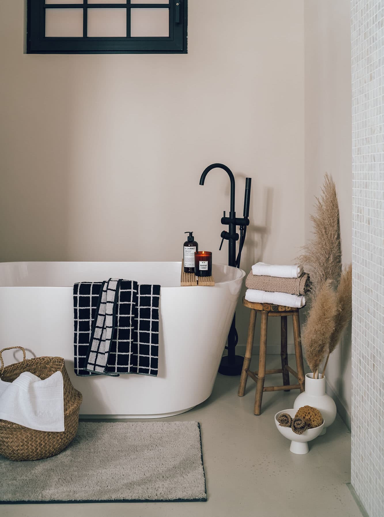 photography still life interior white free standing bathtub high black faucet black and white towels wood stool white and beige towels beige carpet